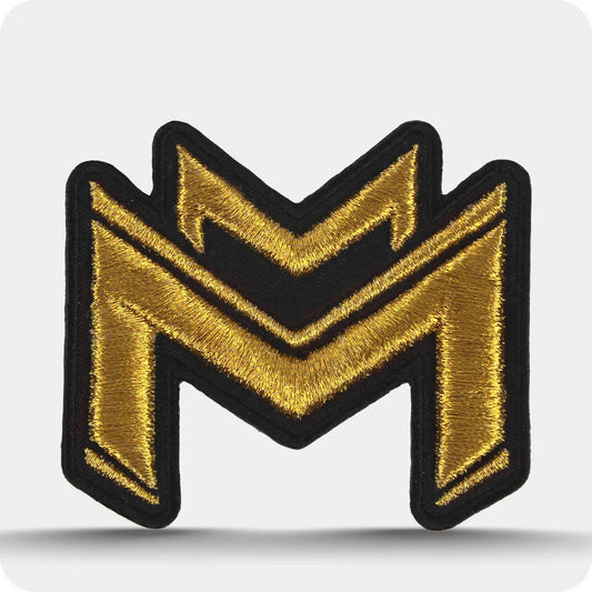 Woven navy clothing label beside a dimensional black and gold embroidered patch